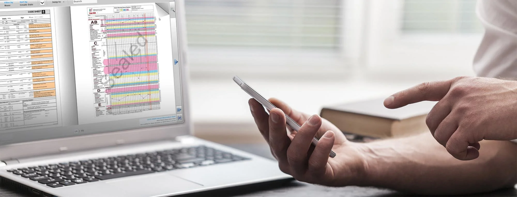 Vitro Digital Medical Record running on a laptop while a clinician reviews a chart on a smartphone